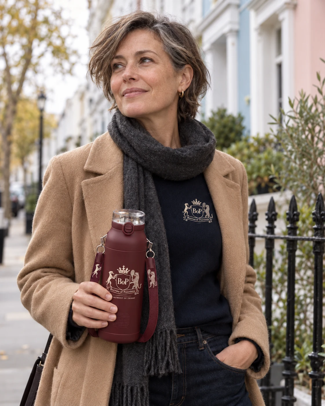 A woman in Notting Hill carrying the burgundy Bureau bottle with its new crest and different strap characters